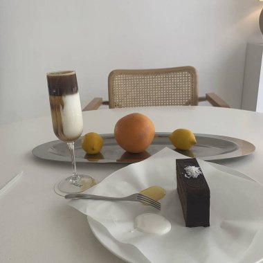 Çikolatalı kek, bir fincan kahve ve masada bir bardak süt.