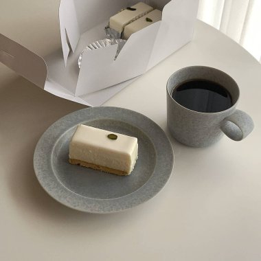 a cup of coffee and a piece of cake on a white plate