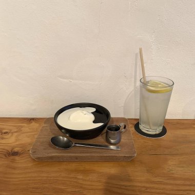 a cup of tea with milk and a spoon on a wooden table