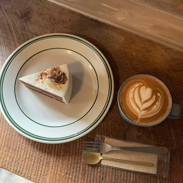 Krem şantili lezzetli bir kahvenin ve bir dilim kekin dikey çekimi.