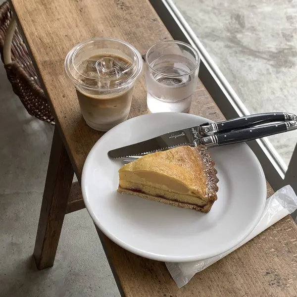 Bir fincan kahve, kek ve kaşık masada.