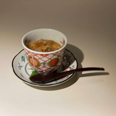 Beyaz arka planda kaşığı olan bir fincan kahve.