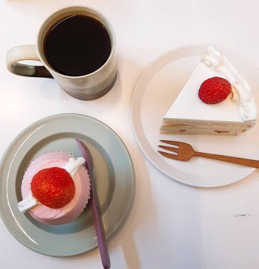 Bir fincan kahve ve çatallı lezzetli bir kekin yakın çekimi.