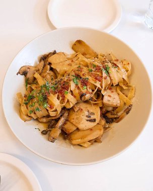 Masadaki beyaz tabakta deniz mahsullü makarna.