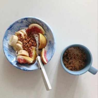 Beyaz arka planda bir kaşık ve kaşıkla bir fincan kahve.