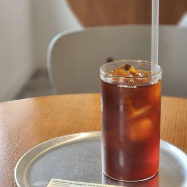 Bardakta buzlu çay, masada saman.