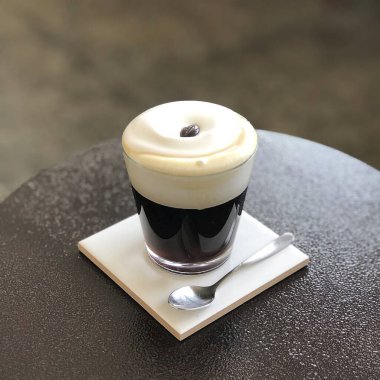 Tahta bir masada sütlü bir fincan kahve