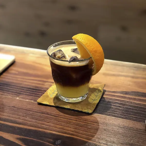 Bir bardak buzlu viski ve ahşap bir masada pipet.