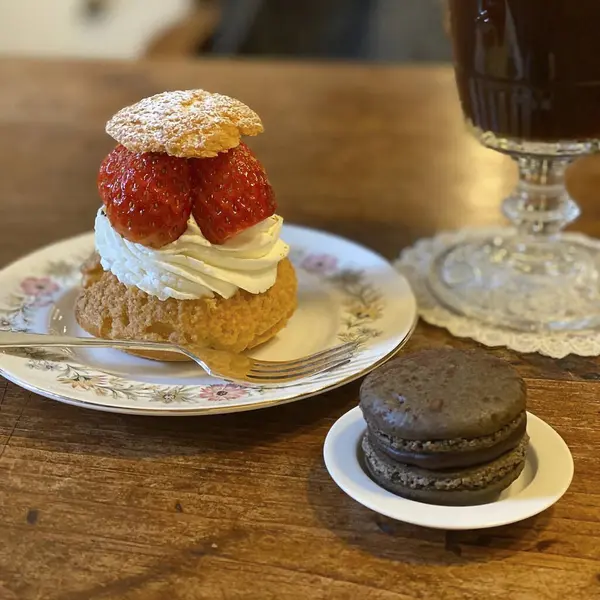 Bir fincanın dikey görüntüsü, masada lezzetli bir pasta ve bir fincan çay.