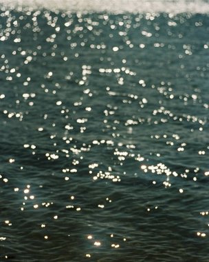 Güneş ışınları ve dalgalı su yüzeyi