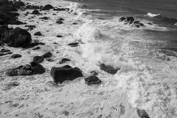 Kayalarla, dalgalarla ve su sıçramalarıyla deniz manzarası