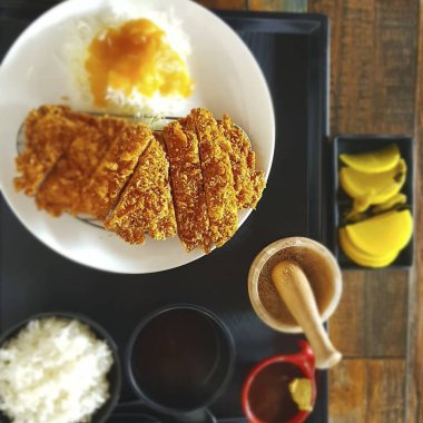 Kızarmış tavuk, pilav ve sebzeler beyaz tabakta.