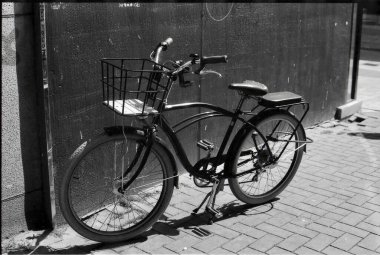 Sokağa park etmiş bir bisikletin siyah beyaz fotoğrafı.