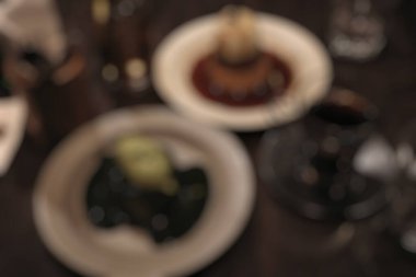 Restoran masasının arka planı şarap ve bardaklarla bulanık.