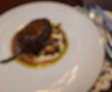 Çatal ve kaşıkla bir restoran masasının bulanık arka planı.