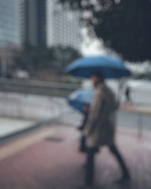 İnsanlar yağmurlu bir günde yolda yürüyor.