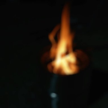 Gecenin karanlığında yanan bir ateşin bulanık arkaplanı