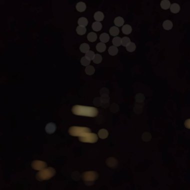 Odaklanamayan soyut arkaplan. Siyah arkaplanda bokeh ışıkları, şenlikli arkaplan