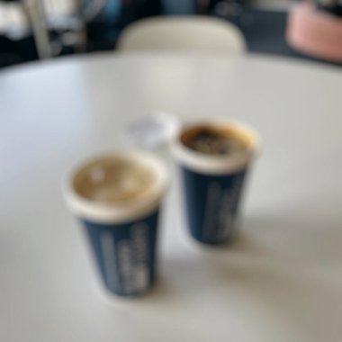 Kafedeki kahve fincanlarının bulanık görüntüsü kahve dükkanının bulanık arka planına sahip.