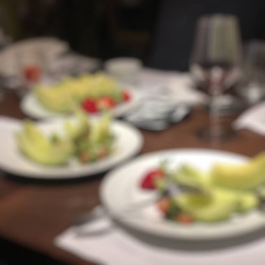 Lokanta masasının bulanık arka planında yemek var.
