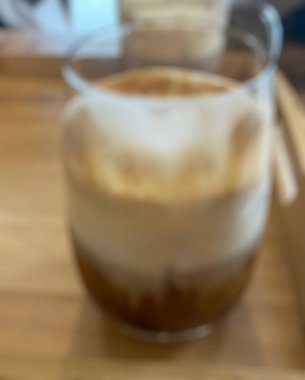 Masanın üzerinde beyaz bardakta kahve.