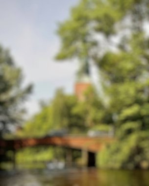 Parkta bulanık bir nehir olan ahşap bir köprünün bulanık arka planı