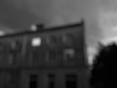 Karanlık ve beyaz bulutlu karanlık şehrin bulanık arkaplanı.