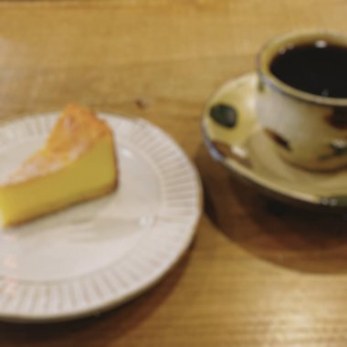 Bir fincan çay ve bir parça kek Tahta bir masanın üzerinde