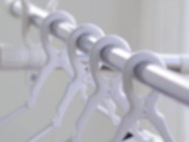 Raftaki beyaz elbise askıları.