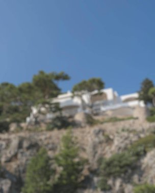 Dağların arka planında ev bulanıklığı ve kopyalama alanı olan mavi gökyüzü..