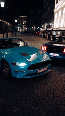 Gece kentinde 2 Ford Mustang. Gece şehrinde arabalar. Yüksek kalite fotoğraf