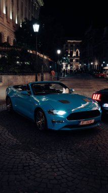 Gece kentinde 2 Ford Mustang. Gece şehrinde arabalar. Yüksek kalite fotoğraf