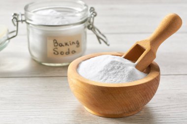 sodium bicarbonate on a white wooden table, selective focus. Environmentally friendly detergent - baking soda on a white wooden table. clipart