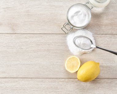 Ev bakımı, kabartma tozu ve limonla doğal sağlıklı temizlik, üst manzara. Çevre dostu deterjan - beyaz ahşap bir masada kabartma tozu, üst manzara.