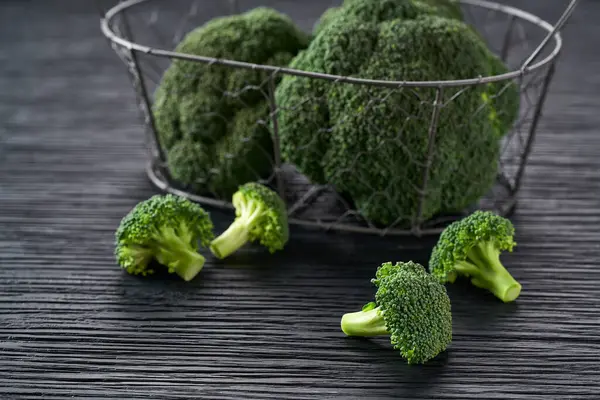 Čerstvě Zelená Brokolice Proutěném Koši Stole Černé Kuchyně — Stock fotografie
