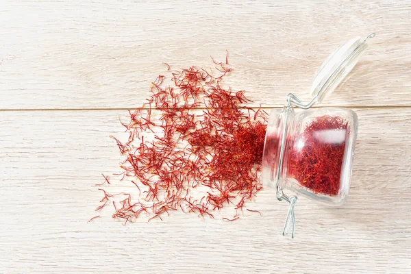 Saffron Thread Spill Out Glass Storage Jar Wooden Table Top — Stock Photo, Image