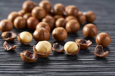 organik Macadamia fındıkları siyah mutfak masasında, seçici bir odak.