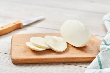 Beyaz bir mutfak masasında dilimlenmiş mozarella bufalosu..