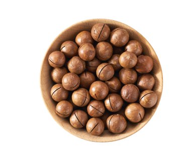 Wooden plate with organic macadamia nuts  isolated on white background, top view.