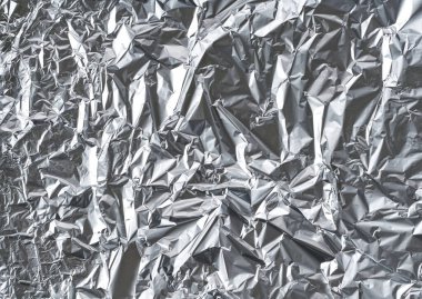 Parlak buruşuk yüzeyi olan gümüş folyo arka plan doku arkaplanı.