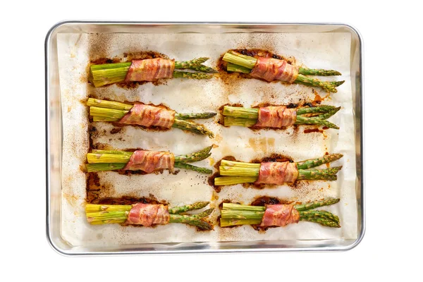 烤成捆的绿色芦笋 包在培根中 放在烤盘上 与白色背景隔离 — 图库照片