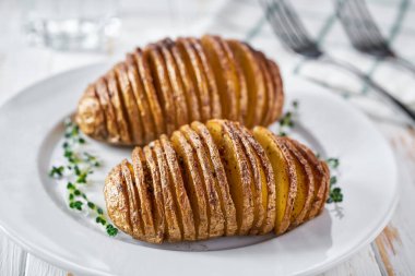 Pişmiş hasselback patatesi. Akordeon fırında patates, sarımsak, kekik ve deniz tuzu. Lezzetli vejetaryen yemekleri.