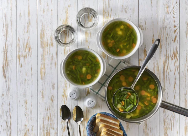 Vegetarisk Maträtt Delikat Soppa Gröna Bönor Ett Vitt Träbord Ovanifrån — Stockfoto
