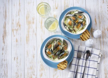 Geleneksel deniz ürünleri çorbası. Beyaz bir masada baget dilimleri..
