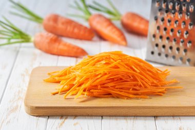 Kesme tahtasında taze rendelenmiş havuç, seçici odak.