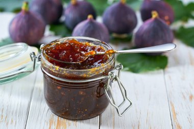 Masaya yakın plan lezzetli incir reçeli. Cam kavanoza yakın plan, incir reçeli beyaz masada taze meyveli, seçici odaklı..