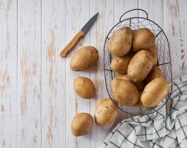 Beyaz ahşap bir masada taze patates odunları..