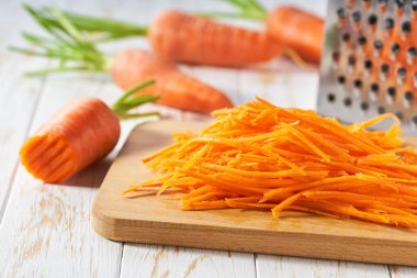 Kesme tahtasında taze rendelenmiş havuç, seçici odak.