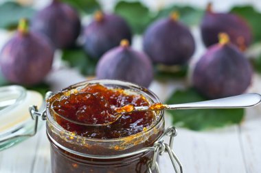 Cam kavanoza yakın plan, incir reçeli beyaz masada taze meyveli, seçici odaklı..