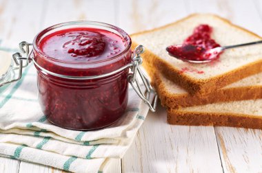 Ahşap mutfak masasında ahududu reçelli lezzetli tost..
